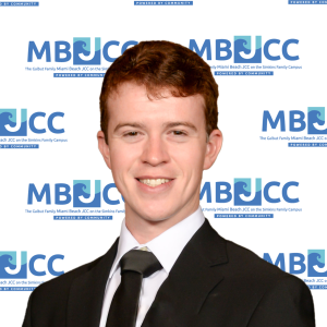 an Image of Maxwell Schrader-Grace on the Miami Beach JCC backdrop. The Director of Marketing
